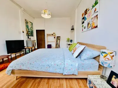 a bedroom with a bed and a flat screen tv at Gallery house 177-3min walk BTS near icon siam in Bangkok