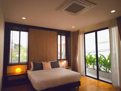 a bedroom with a large bed and windows with a view at Studio Sukumvit 29 in Bangkok