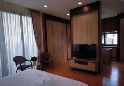 a hotel room with a bed and a flat screen tv at Studio Sukumvit 29 in Bangkok