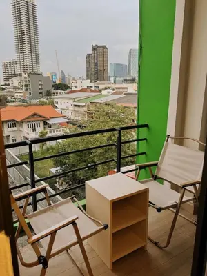 two chairs and a table on a balcony with a view at Holy Hostel Sathorn in Thung Maha Mek