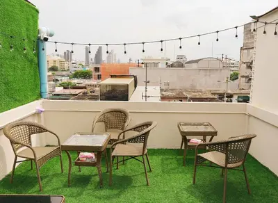 a group of chairs and tables on a balcony at Holy Hostel Sathorn in Thung Maha Mek