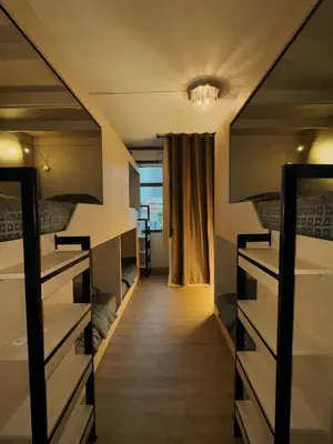 a room with two bunk beds and a hallway at Holy Hostel Sathorn in Thung Maha Mek