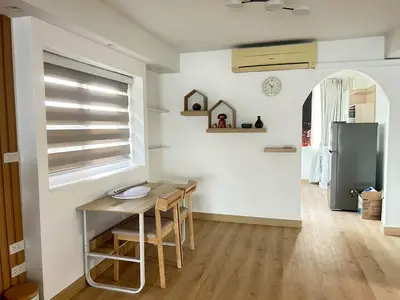 a small kitchen with a table and a refrigerator at บ้านริมน้ำ bann rim num in Bangkok