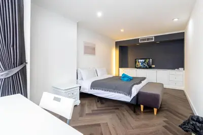 a bedroom with a bed and a chair in it at Omni Nuvél 4 Sukhumvit Branded Suites in Bangkok