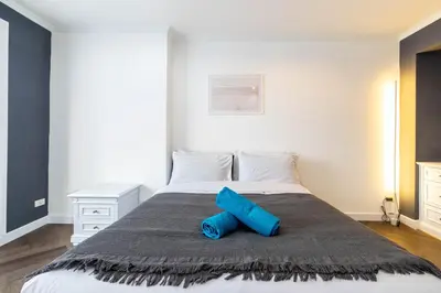 a bed with a blue pillow on top of it at Omni Nuvél 4 Sukhumvit Branded Suites in Bangkok