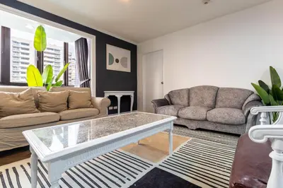 a living room with a couch and a coffee table at Omni Nuvél 4 Sukhumvit Branded Suites in Bangkok