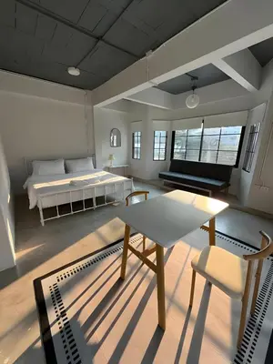 a room with a bed and a table and a couch at Yellow Place Sukhumvit Soi 2 -เยลโล เพลส สุขุมวิทซอย 2 in Bang Kapi