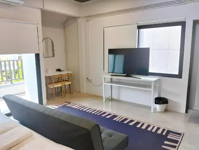 a living room with a couch and a tv at Yellow Place Sukhumvit Soi 2 -เยลโล เพลส สุขุมวิทซอย 2 in Bang Kapi