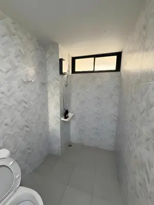 a bathroom with a toilet and a window at Yellow Place Sukhumvit Soi 2 -เยลโล เพลส สุขุมวิทซอย 2 in Bang Kapi