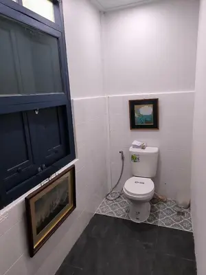 a bathroom with a white toilet and a window at Cat in the box homestay in Godown