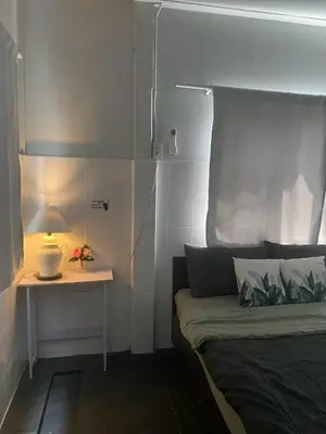 a bedroom with a bed and a table with a lamp at Cat in the box homestay in Godown