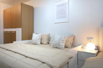 a bedroom with a large white bed with pillows at 4 guests condo near Impact, Wi-Fi & washer C5 in Ban Bang Phang