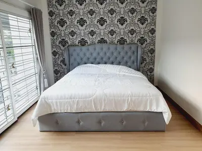 a bed with a blue headboard in a bedroom at Comfy Townhome 5min walk to 7-11 in Ban Nong Bua