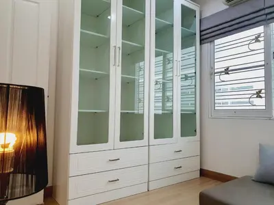 a bedroom with white cabinets and a tv at Comfy Townhome 5min walk to 7-11 in Ban Nong Bua