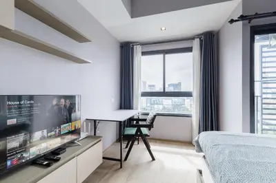 a bedroom with a tv and a bed and a desk at \u65e0\u8fb9\u6cf3\u6c60 JODD \u591c\u5e02\u5bf9\u9762 mrt rame 9 \u6708\u79df\u4f18\u60e0 in Bangkok