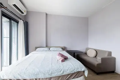 a bedroom with a bed and a couch at \u65e0\u8fb9\u6cf3\u6c60 JODD \u591c\u5e02\u5bf9\u9762 mrt rame 9 \u6708\u79df\u4f18\u60e0 in Bangkok