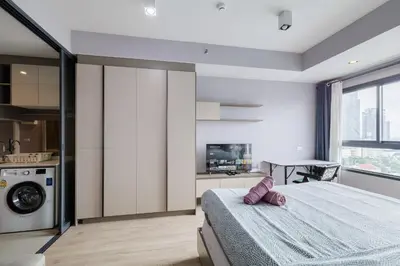 a bedroom with a bed and a washing machine at \u65e0\u8fb9\u6cf3\u6c60 JODD \u591c\u5e02\u5bf9\u9762 mrt rame 9 \u6708\u79df\u4f18\u60e0 in Bangkok