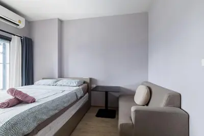 a bedroom with a bed and a chair at \u65e0\u8fb9\u6cf3\u6c60 JODD \u591c\u5e02\u5bf9\u9762 mrt rame 9 \u6708\u79df\u4f18\u60e0 in Bangkok