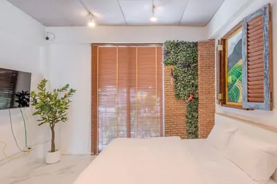 a bedroom with a white bed and a brick wall at Rooftop at Ladprao The Mall Bangkapi BTS 4BR with Lift in Ban Bang Toei (1)