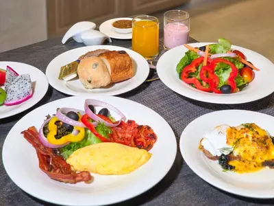 a table with plates of breakfast food on it at Away Bangkok Sukhumvit in Bangkok