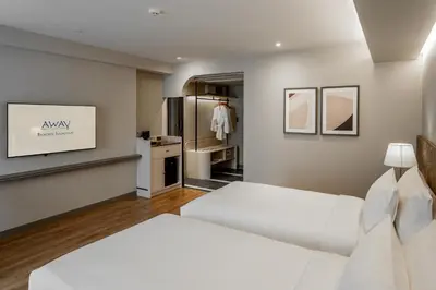 a bedroom with two beds and a kitchen at Away Bangkok Sukhumvit in Bangkok