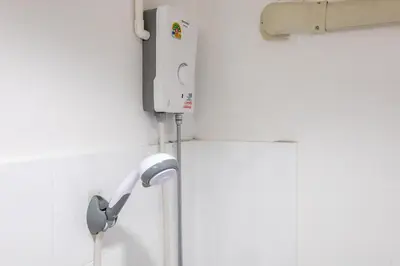 a shower in a bathroom with a shower head at Calmly Stay Ratchada in Bangkok