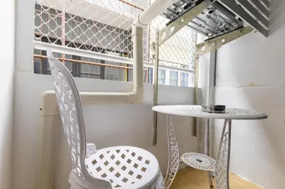 a chair and a table in a room with a window at Calmly Stay Ratchada in Bangkok