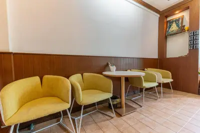 a waiting room with yellow chairs and a table at Calmly Stay Ratchada in Bangkok