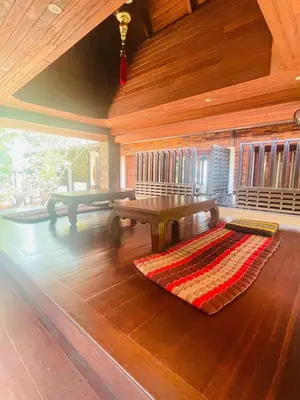 a living room with a bench and a rug on the floor at Yotaka Boutique Hotel Bangkok in Bangkok