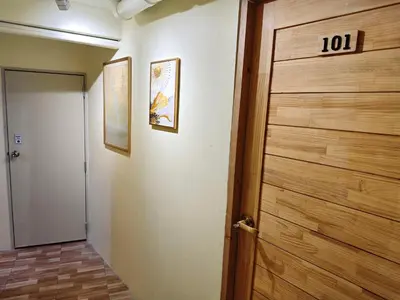 a hallway with a wooden door with the number at latitude 13 Room & breakfast in Bangkok