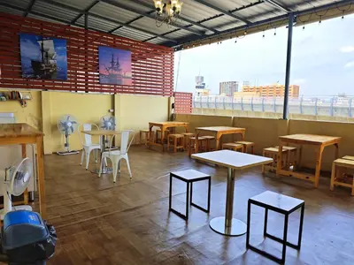 a restaurant with tables and chairs and a large window at latitude 13 Room & breakfast in Bangkok