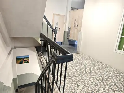 a staircase with a black rail and a tile floor at latitude 13 Room & breakfast in Bangkok