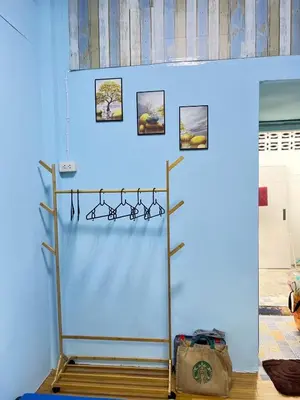 a blue wall with a rack with pictures on it at 214 Lovely apartment with private bathroom and WiFi in Bangkok