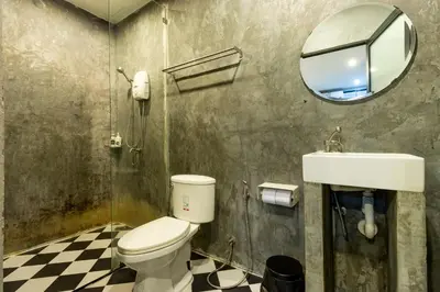 a bathroom with a toilet and a sink and a mirror at The Secret Service in Bangkok