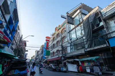 a person riding a motorcycle down a city street at The Secret Service in Bangkok