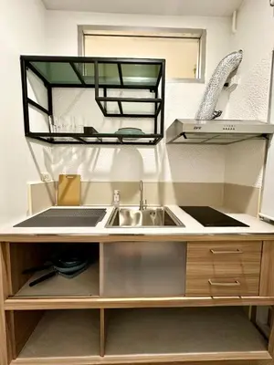 a kitchen with a sink and a mirror above it at Studio Botanica I 2 mins to SRT in Bangkok