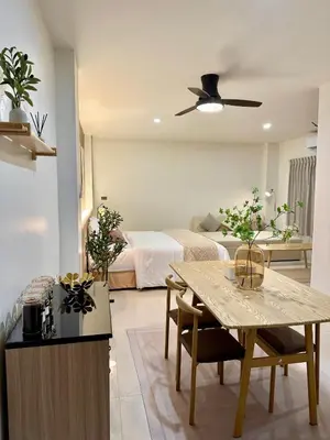 a living room with a bed and a table with chairs at Studio Botanica I 2 mins to SRT in Bangkok