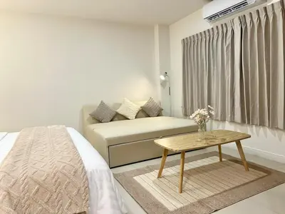a living room with a couch and a table at Studio Botanica I 2 mins to SRT in Bangkok