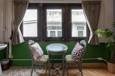 a green room with a table and two chairs at Sao Chingcha Near Khao San Road MRT 3 bathtub in Bangkok