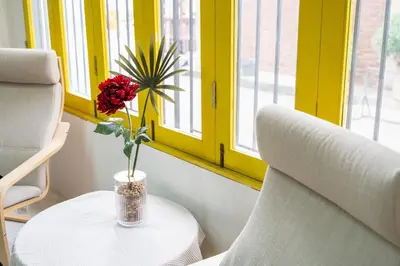 a vase with a flower on a table next to a chair at Sao Chingcha Near Khao San Road MRT 3 bathtub in Bangkok