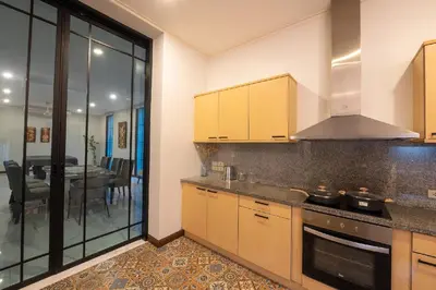 a kitchen with yellow cabinets and a dining room at Sukumvit Pool Villa 5BR 5-7min-walk to Thonglor Sky train in Khlong Toei