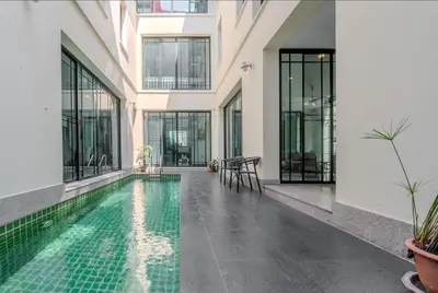 a swimming pool in the middle of a building at Sukumvit Pool Villa 5BR 5-7min-walk to Thonglor Sky train in Khlong Toei