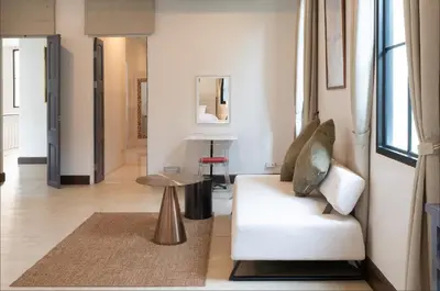 a living room with a white couch and a table at Sukumvit Pool Villa 5BR 5-7min-walk to Thonglor Sky train in Khlong Toei