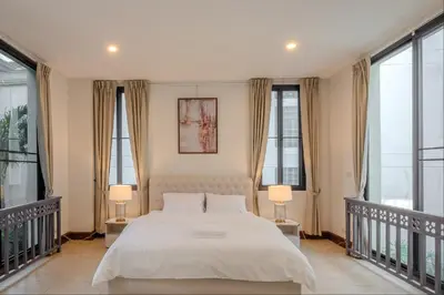 a bedroom with a large white bed with two lamps at Sukumvit Pool Villa 5BR 5-7min-walk to Thonglor Sky train in Khlong Toei