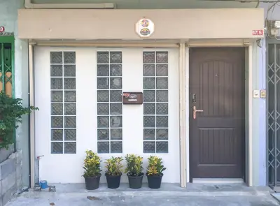 a house with potted plants in front of a door at HOME175 Peaceful 2BR near BTS & IconSiam in Bangkok