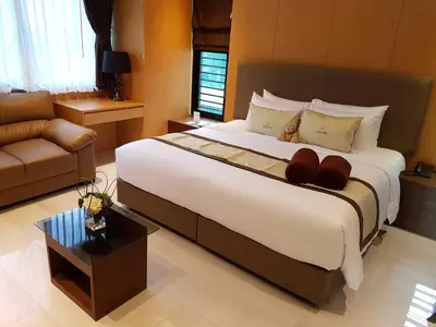 a bedroom with a large bed and a couch at Syama Suite Sukhumvit 20 in Bangkok