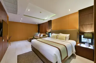 a hotel room with a large bed and a couch at Syama Suite Sukhumvit 20 in Bangkok