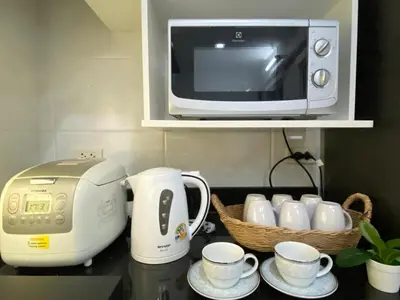 a kitchen counter with a toaster and cups and a microwave at Cozy home near impact arena in Nonthaburi