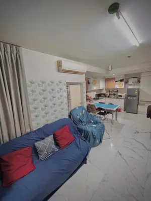 a living room with a blue couch and a kitchen at Condo In Bangkok With Pool and Garden in Sathani Ban Hua Mak