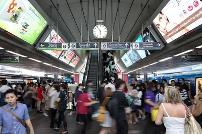 a crowd of people in a subway station with a clock at XX GO INN Asiatique Bangkok - โกอินน์ เอเชียทีค เจริญกรุง in Bangkok